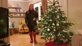 Decorating Christmas tree in rainwear, latex leggings and rubber boots
