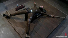 Submissive girl in latex bodysuit gets punished by a girl