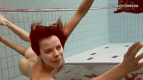 Katya Okuneva is slowly taking off her clothes in the swimming pool, while under water